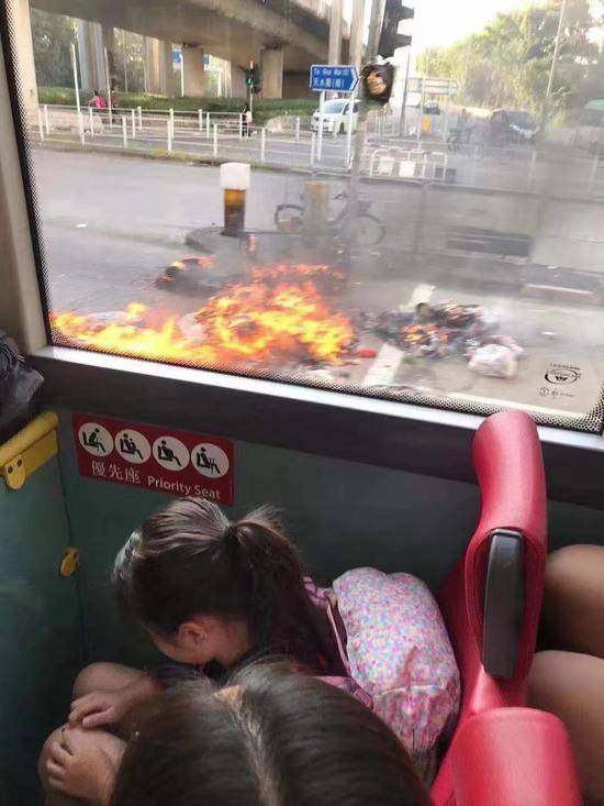 巴士驶过被暴徒纵火的路口，有学童被惊吓低头（大公网）