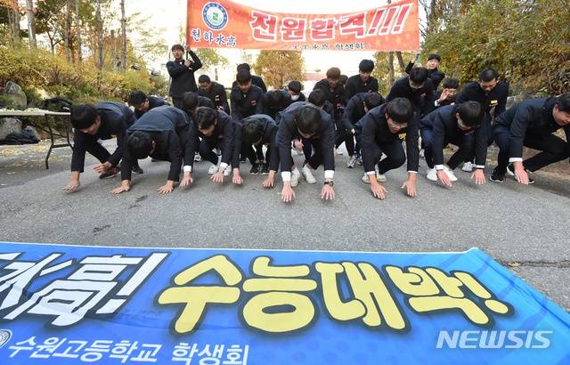 14日，韩国京畿道某高中前，后辈为参加高考的前辈行大礼。（纽西斯通讯社）