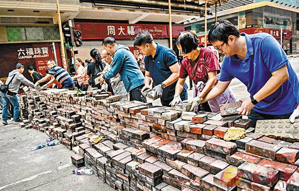 15日清晨，香港市民走上街头，清理路障杂物。（图源：《文汇报》）