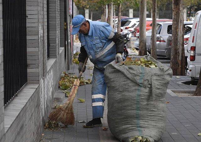 东九路，一名环卫工人在寒风中清扫落叶。