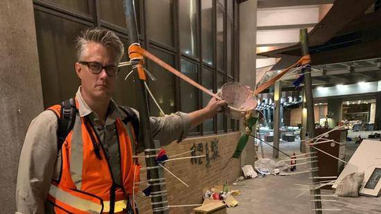  Jim Spellman poses with a makeshift catapult at the campus of Hong Kong Polytechnic University。/CGTN Photo