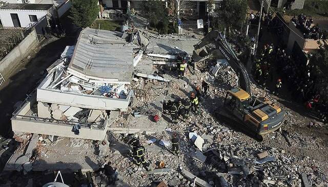  11月27日，在阿尔巴尼亚都拉斯，救援人员在一栋地震中倒塌建筑的废墟中寻找幸存者。新华社图