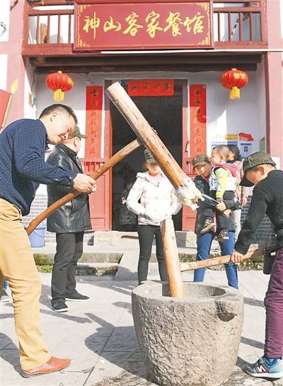 到井冈山市神山村做客的外地人同村民一起打糍粑。新华社记者万象摄