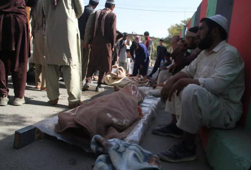 9月29日，在阿富汗东部加兹尼省，人们守护在空袭中遇难的平民遗体旁。新华社发（鲁胡拉摄）