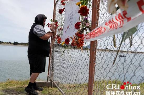 当地时间2019年12月11日，新西兰瓦卡塔尼，一名男子在港口的纪念栏前献花，悼念怀特岛火山喷发遇难者。
