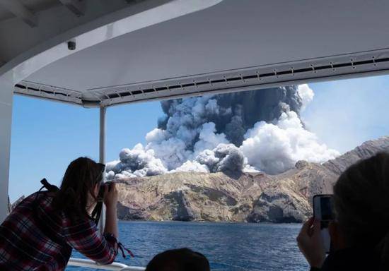  12月9日，一名游客在船上拍摄新西兰怀特岛火山喷发的情景。新华社发（迈克尔·谢德供图）