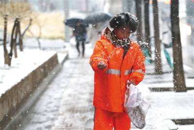 慈云寺桥，环卫工人撒融雪剂。新京报记者薛珺摄