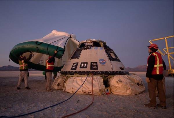 工程师们检查落地后的太空舱并准备为太空舱架起帐篷图自 NASA官方网站