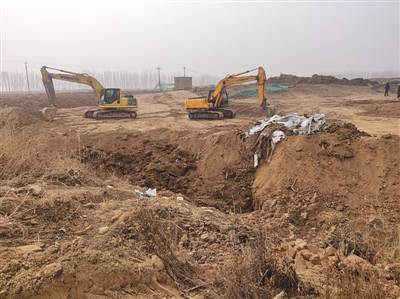 12月23日上午，工作人员从现场窑坑底部挖出了铁桶和塑料等废弃物。新京报记者陈奕凯摄