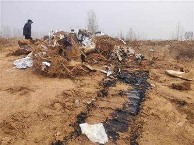 12月23日上午，工作人员从窑坑底部挖出了铁桶和塑料等废弃物。新京报记者陈奕凯摄
