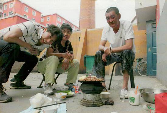 徐志夫夫妇和一名日本记者在空地吃烤肉。日本一些民间团体曾对受害群体表示过关心和帮助。但对不少受害者来说，微薄的补助仍是杯水车薪。