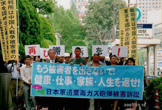 2007年7月18日，日本东京游行现场。游行由日本律师和民间支持会组织，受害人李臣、孙文斗走在队伍最前面。