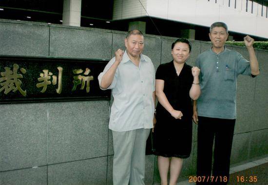 2007年7月18日，日本东京高等法院前，毒气受害者李臣、孙文斗与律师罗立娟握紧拳头，为自己打气。