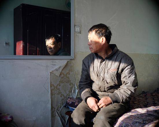 梁红格，生于1963年。2003年，他戴着手套在齐齐哈尔北疆小区收捡废钢，没能逃过被感染的命运。