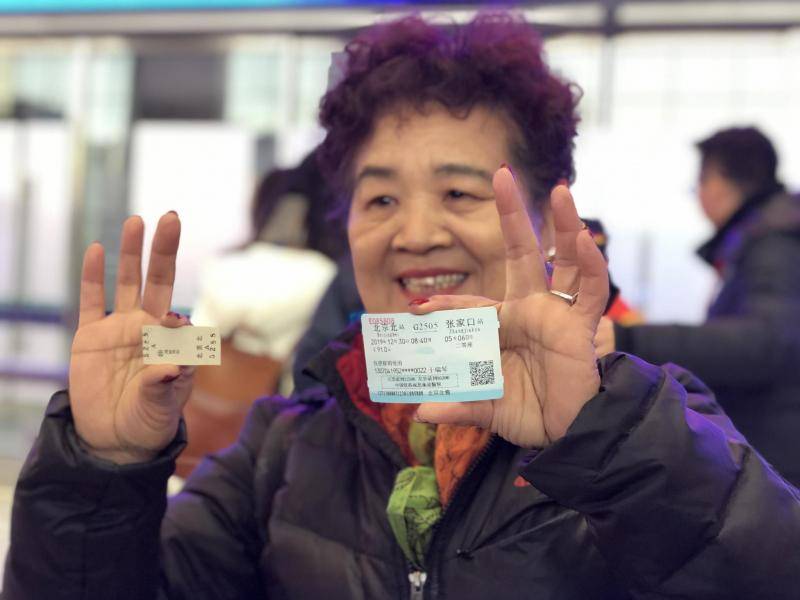 12月30日，京张高铁开通首日，于瑞琴带来一张过去的纸板票，和今天的高铁票一起合影留念。摄影/新京报记者周依