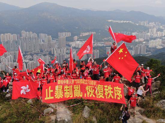  9月14日，百余名香港市民分两批爬上狮子山顶，他们身穿红色T恤，挥舞国旗、区旗，并展示“庆祝中华人民共和国成立70周年”和“止暴制乱，恢复秩序”的横幅。