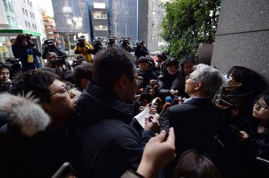 △戈恩在东京的代理律师广中纯一郎被媒体团团围住（图/AFP）