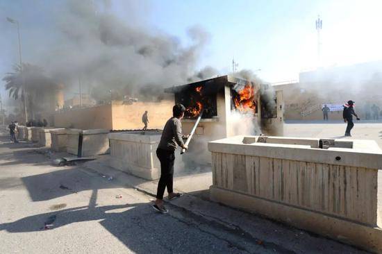 这是2019年12月31日在伊拉克巴格达美国驻伊拉克大使馆外拍摄的示威者点燃一间保安室。新华社发