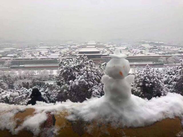 游客登景山堆雪人 赏“紫禁城雪景”