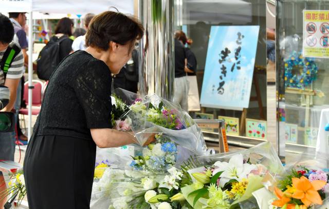 家属在相模原市残疾人福利院为逝去的亲人献花（朝日新闻）