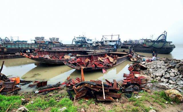 江西九江整治长江非法采砂船，在江西九江一处采砂船集中切割点，工作人员对采砂船进行切割作业。