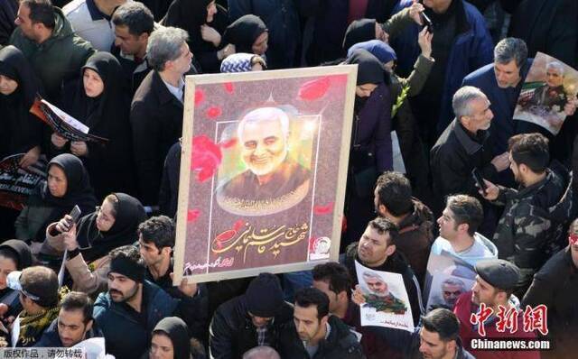 当地时间1月6日，成千上万的伊朗民众走上德黑兰街头，向被美军击杀的高级军官苏莱曼尼表示敬意。图为追悼会上民众高举苏莱曼尼的照片。