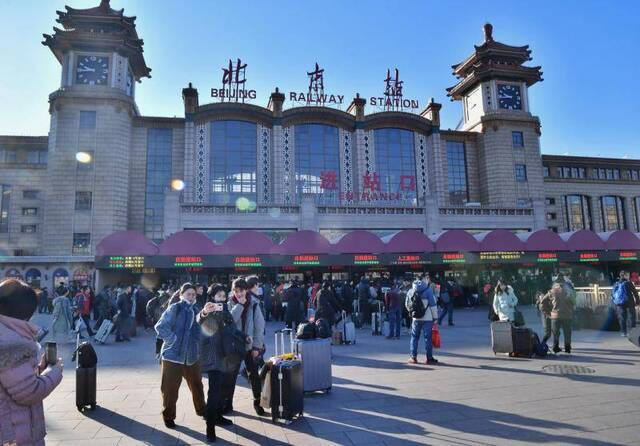  1月10日，春运首日，旅客在北京站前拍照留念。