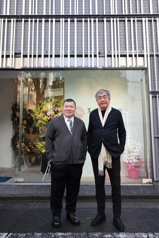 在日本东京银座，王传峰（左）和隈研吾在王传峰美术馆门口合影。新华社记者杜潇逸摄