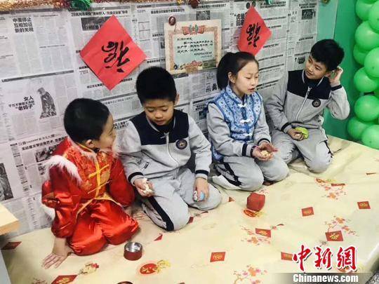 资料图：学生在体验东北民俗火炕刘栋摄