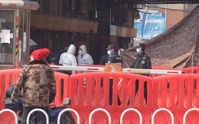 1月20日上午，武汉华南海鲜市场内，多身穿白色防护服的工作人员正在进行防疫工作。新京报记者游天燚摄