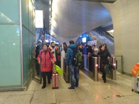 1月19日22时许，武汉高铁站出站闸机处，仅有不到三分之一的乘客佩戴了口罩。新京报记者海阳摄