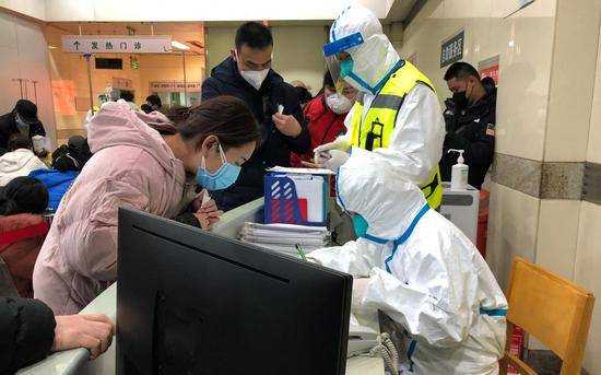 同济医院发热门诊内，“全副武装”的医护人员及戴着口罩的患者。新京报记者向凯摄