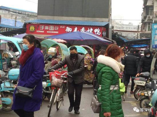 面对疫情，防护要做，年货也要买。图为武汉市蔡甸区最大的菜市场出入口。《等深线》记者王迎春摄