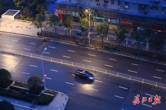 图为早上7时15分，天刚刚亮，路灯还没有熄灭，已经有车辆在香港路上行驶，武汉醒了。