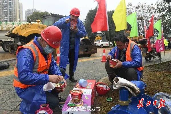 在武汉小汤山模式医院建设现场，一群施工者们正在吃着方便面做午餐。记者詹松摄