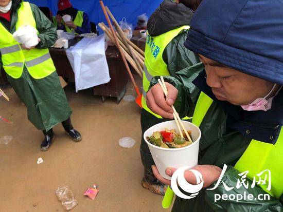 火神山医院工地现场的工人正在用餐。人民网记者崔东摄