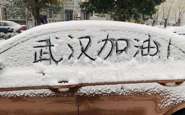 北京迎鼠年首场降雪，市民雪中写“武汉加油”