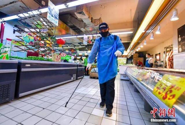 资料图：超市工作人员在喷洒消毒液。中新社记者刘新摄