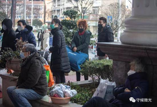 2月3日，武汉市硚口区一家被改为新冠肺炎隔离点的维也纳酒店门口，来自各个社区的“四类人员”等待入住。该酒店提供免费住宿和一日三餐，入住前须测量体温。中青报·中青网记者李峥苨/摄