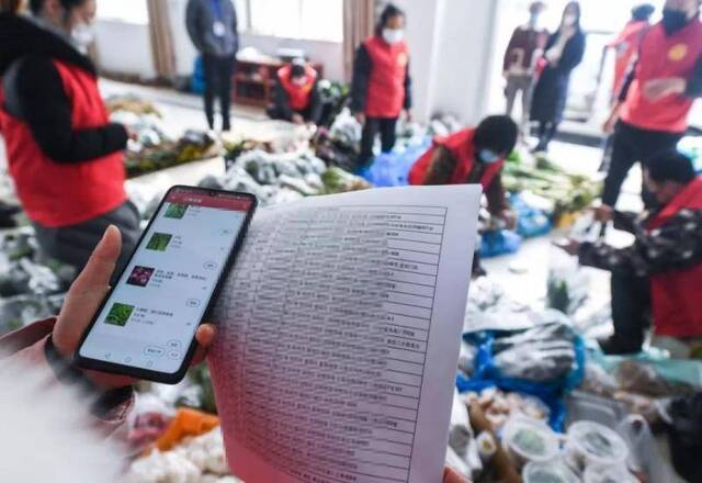 2月9日，志愿者在杭州一家农业公司按照网上平台订单准备为当地居民配送各类蔬菜、禽蛋。新华社记者徐昱摄