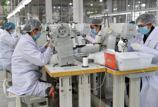 2月7日，在制鞋企业莆田双联鞋业有限公司的生产车间，工人在缝制口罩。（新华社记者魏培全摄）