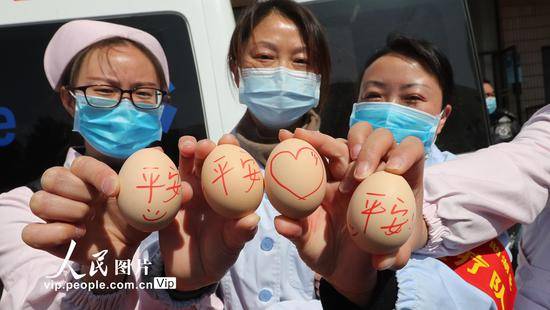 2020年2月4日，云南省昆明市，出征队员手中写着“平安”的鸡蛋，包含了“平平安安”和“平安回来”的祝福。杨峥/人民图片