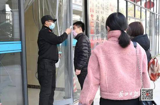 ▲1月31日，汉阳区龙阳街办事处，保安给工作人员测体温长江日报记者金思柳摄