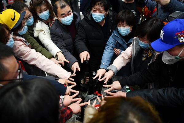 2月9日，在天津滨海国际机场，天津市第五批支援湖北医疗队启程。医疗队员和前来送行的人围成一圈加油打气。新华社图