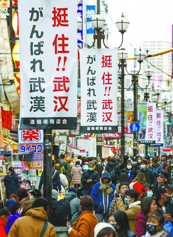 10日，日本大阪道顿堀商圈的街道上挂起中日双语的“挺住！！武汉”标语。近日，日本各界以不同形式为中国抗击新冠疫情加油鼓劲。