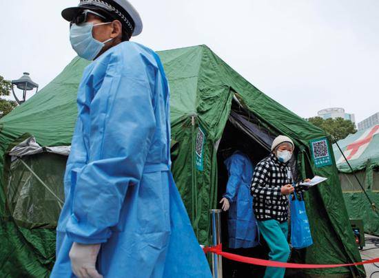 2月3日，上海长海医院架设3顶军队野战帐篷作为入院通道，患者在此初检、测体温、登记健康信息。摄影/雍和