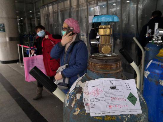 2月7日，武汉同济医院发热门诊，一位患者正从空氧气瓶前走过。