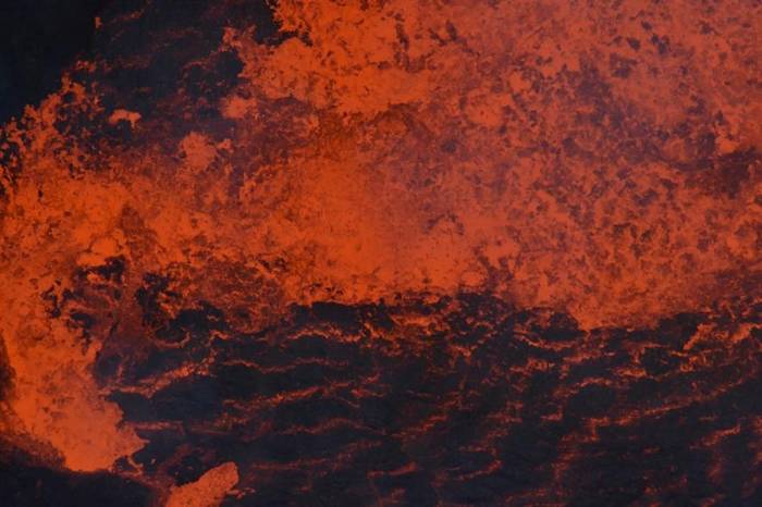 在2018年爆发前，熔岩在安布理姆的一座湖里翻搅。熔岩湖的作用就像是直通深处的一扇窗，提供了地底深处究竟发生了什么的线索。 PHOTOGRAPH BY DAN
