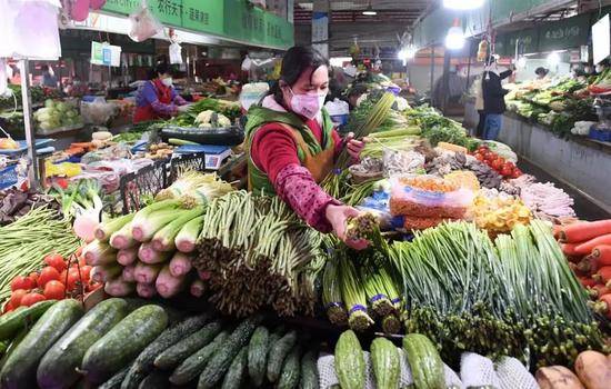 1月30日，在广西南宁市埌东六组综合农贸市场，一名摊贩在摆放蔬菜等待销售。新华社记者陆波岸摄