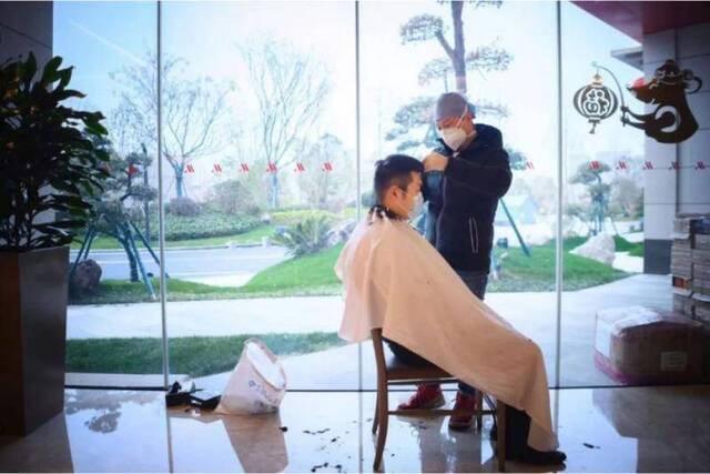 2月15日刊发的“快递小哥”一文中甘师傅正在为医护人员理发